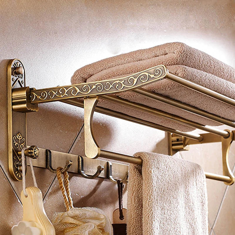 he Capri antique brass wall-mounted foldable bath towel rack with hooks.