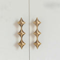 The Celestial Edge unique star-shaped solid brass furniture handles in gold.
