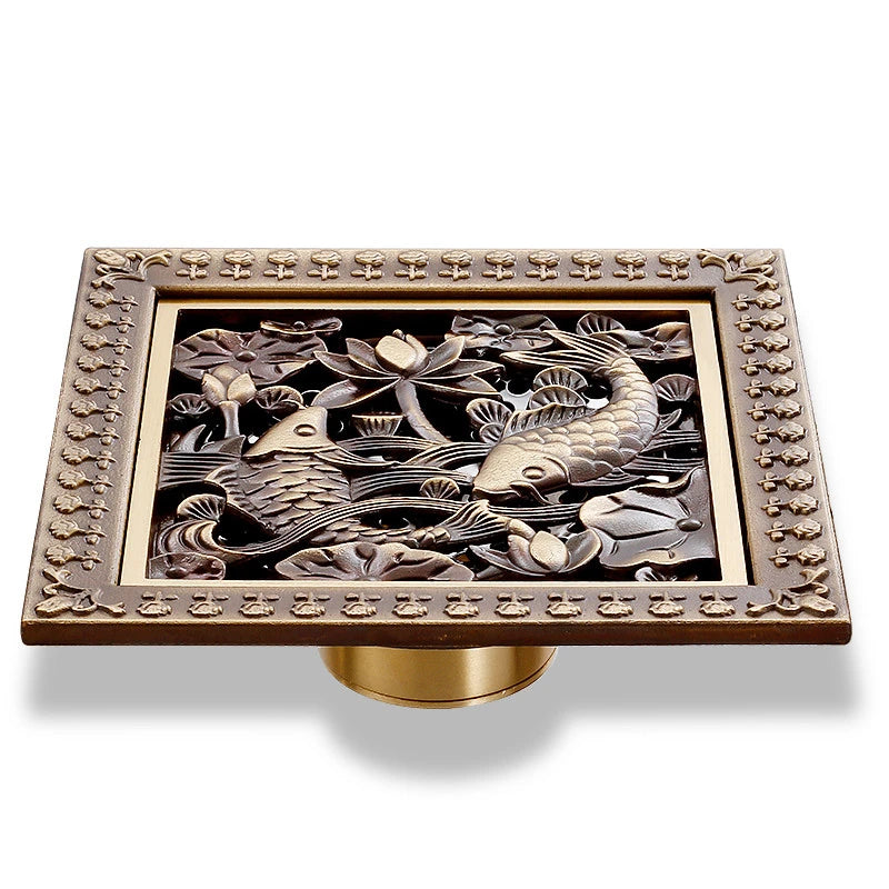 Collection of 12 antique brass carved square shower drains with ornate designs including floral medallion, geometric mandala, sailing boat, and nature motifs