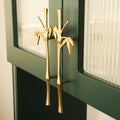 BAMBOO sculptural cast brass cabinet door handle in polished gold on dark green cabinet — botanical wardrobe pull