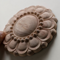 Round floral wood carved rosette applique for furniture and cabinet decoration.