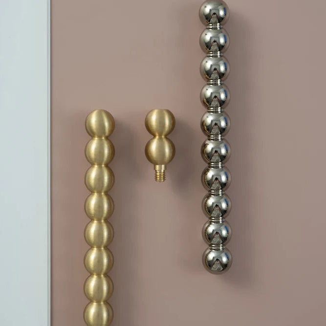 PERLA antique brass beaded ball cabinet handles and knobs in multiple sizes on pink background