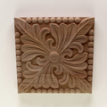 Wooden decorative panel with intricate floral design on a white background